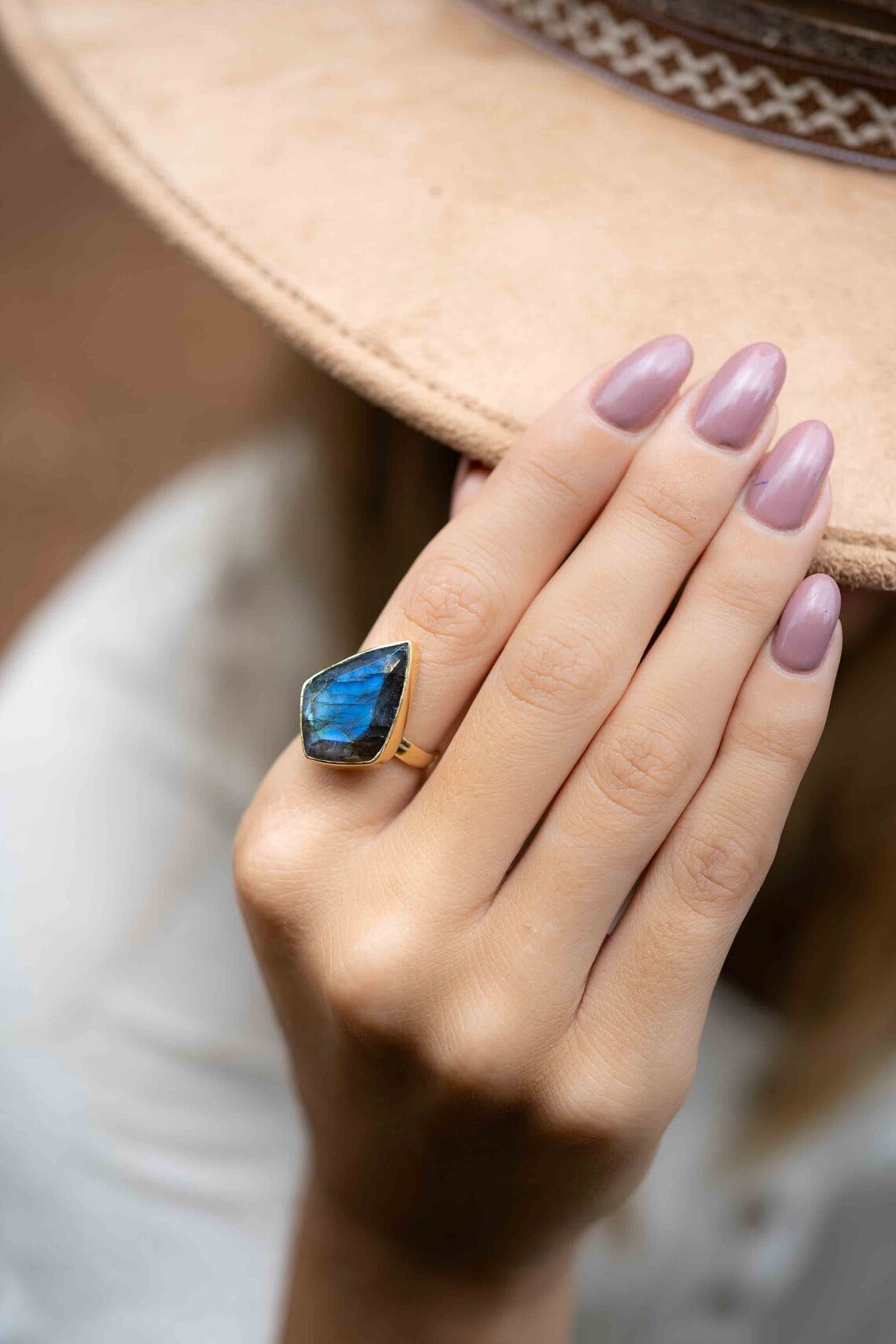 rainbow labradorite gold ring on the woman's finger